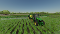 In-game view of John Deere 5M Series utility tractor spreading the herbicides using the R732i PowrSpray sprayer